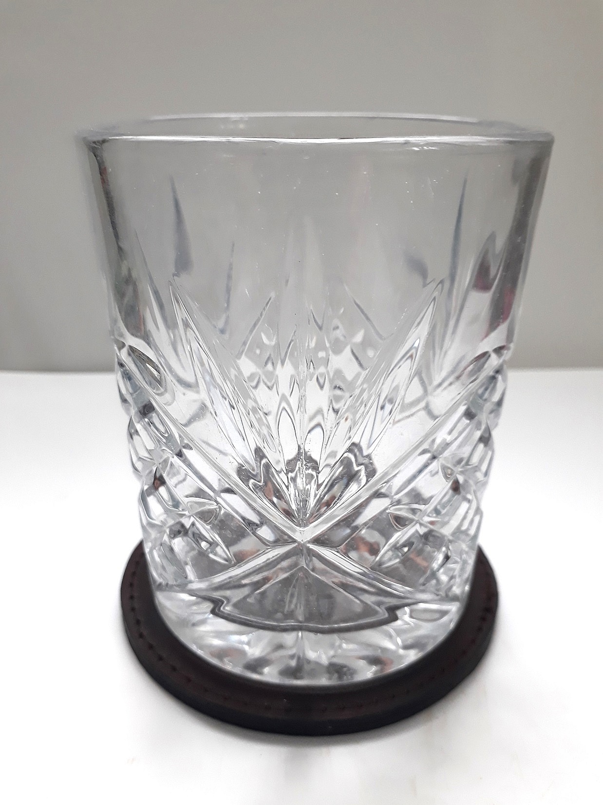 Dessous de verre personnalisé noir sous un verre en cristal.